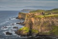 Dunluce Castle illuminated by sunlight, perched on the edge of cliff, Northern Ireland Royalty Free Stock Photo