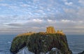 Dunnottar Castle perched high on the Conglomerate Cliffs lit up by the setting evening light Royalty Free Stock Photo