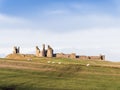 Dunstanburgh Castle on the Northumberland coast with copy space Royalty Free Stock Photo