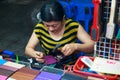 Duong Dong city, Phu Quoc, Vietnam - December 2018: woman making beautiful cover for passport on night market.