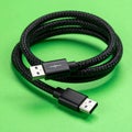 Durable Black Braided USB Cable on Green Background Royalty Free Stock Photo