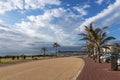 Paved Promenade Against Coastal Landscape and Blue Cloudy Sky Royalty Free Stock Photo