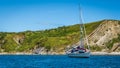 A yacht anchored at Lulworth Cove near Durdle door on a bright sunny summer weekend with the coastal cliff Royalty Free Stock Photo