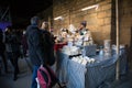 Cheese stall at a food market showing vendor and customers looking at goods