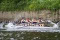 Four female rowers competing in regatta with oars splashing in the water
