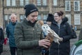 Young man holding a white owl bird of prey with a gloved hand