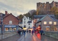 People walk on Framwellgate Bridge in evening with Durham Castle in background Royalty Free Stock Photo