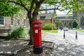 Traditional red post box that sits wonky at the Cathedral and Castle in Durham city centre