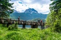 Tourists man on wooden footbridge over stream and Glacial Black Lake. Durmitor National Park. Montenegro