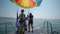 Two girls prepare for take off from boat at parasailing at Beach