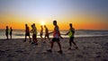 Football sport team is engaged in jogging training at sea at sunset