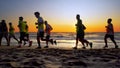 Football sport team is engaged in jogging training at sea at sunset