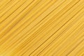 Uncooked durum fettuccine pasta background. Close up of raw spaghetti. Full frame of noodles