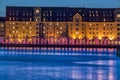 Dusk or blue hour harbour vibes with water reflection of Scandinavian historical buildings and the installation The Gate of Lights