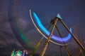 Dusk carnival ride swinging with blurred lights at county fair Royalty Free Stock Photo