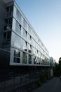 Dusk falling on a modern 4-story glass building in Nyon Switzerland