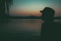 Dusk Woman Lake Silhouette against Orange Sky mountains background. Free woman enjoying freedom feeling happy at sunset. Serene