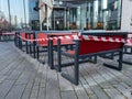 Dusseldorf, Germany - December 25, 2020: Empty benches and tables separated with red and white tape. Closed restaurant