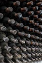 Dust covered wine bottles aging in an underground winery