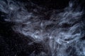 Dust particles cloud generating abstract shape on black background with copy space for text.