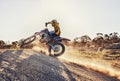 Dust, race and man on dirt bike in desert with adventure, adrenaline and speed in competition, Extreme sport, trick and Royalty Free Stock Photo