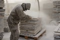 dustcovered worker stacking marble tiles on pallet Royalty Free Stock Photo