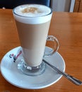 and dustedlatte topped with frothy milk served in a tall glass