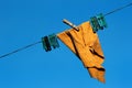 Duster with pegs on a clothesline against blue sky background Royalty Free Stock Photo
