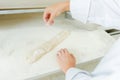 Dusting baguette with flour Royalty Free Stock Photo