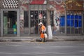 A dustman with an orange suit on the street