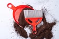 Dustpan, broom and soil on the floor.