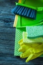 Dustpan brush sponges protective gloves washcloth on wooden boar