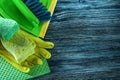 Dustpan brush sponges safety gloves dishcloth on wooden board Royalty Free Stock Photo