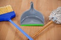 Dustpan, sweeping broom and mop on wooden floor