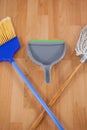 Dustpan, sweeping broom and mop on wooden floor