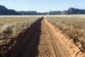 Dusty desert road to nowhere. Southern Namibia. Royalty Free Stock Photo