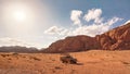 Dusty desert with rocky massif and blue sky above, off road desert vehicle in foreground. Typical scenery in Wadi Rum, Jordan Royalty Free Stock Photo