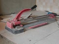 A dusty grungy tile cutter on freshly laid tiles - tiling tool / equipment