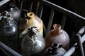 Dusty, rustic old glass demijohns or wine bottles in a wooden ra