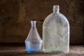 Dusty vintage bottles. Antique glassware on an old shelf. Royalty Free Stock Photo