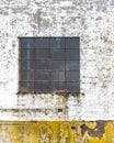 Window with rusty bars on the peeling wall of an old industrial building Royalty Free Stock Photo