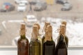 Dusty wine bottles stand on the window sill