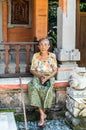 Old lady sits in front of house at family compound, Dusun Ambengan, Bali Indonesia