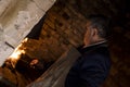 Dutch angle shot of an aged blacksmith near a fire