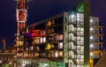 Dutch architecture by night, lighted apartments building with staircase and balconies