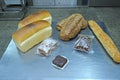 Dutch bakery products placed on a tray: bread, rolls, muffins, machines of an automatic dough line on the background Royalty Free Stock Photo