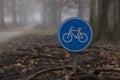 Dutch bicycle path sign in enchanted forest fog