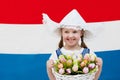 Dutch child with tulip flowers and Netherlands flag