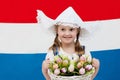 Dutch child with tulip flowers and Netherlands flag