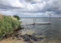 dutch clouds at a lake with a small pier Royalty Free Stock Photo